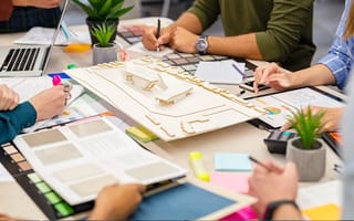 Team of architects and engineers working on urban building model scale.