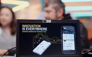 Laptop displaying innovation is everywhere text along with a mockup of the Caterpillar app on a mobile phone