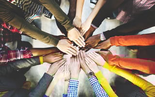 Close up of a diverse group of people stacking their hands together