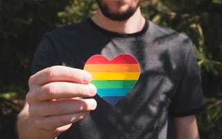 Man holding a paper heart in the colors of rainbow