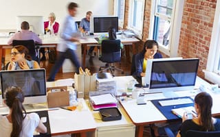 Wide angle view of a busy office with workers at desks