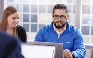 Two Wipfli team members looking at a laptop