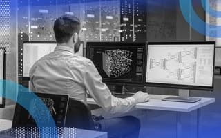 A data scientist works on multiple computer monitors