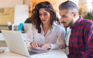 coworkers looking at a laptop discussing a project
