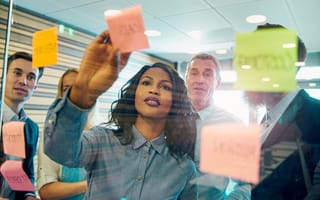 Group of colleagues brainstorming with post it notes on the wall