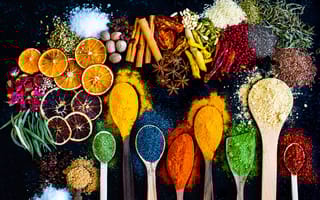 Many multi colored spices and dried fruits on the table