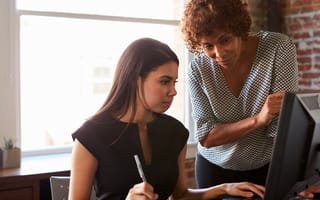 Two women working on a computer in an office