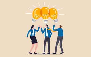 Three people look up at three yellow lightbulbs that symbolize new ideas