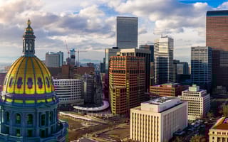 Colorado State Capitol Building & the City of Denver Colorado at sunset with the Rocky Mountains on the horizon