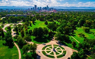 a park with the denver skyline in the background