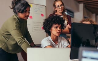 Women engineers looking at a computer monitor working on a project together