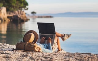 a person using a laptop on a beach