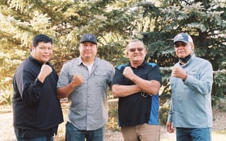 Indigenized Energy Initiative's team posing in front of evergreen trees.