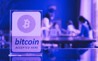 Purple bitcoin "accepted here" sign.