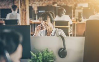 A customer service representative answers a phone call in an office