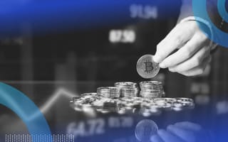 A hand adds a Bitcoin to a stack in front of market trend lines