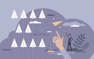Array of paper airplanes, one moving in a separate direction with a hand and a man both pointing to it.