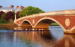 Rowers cross under a bridge on the Charles River