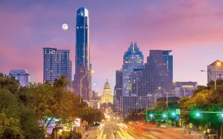 The Austin skyline photographed at dusk as the moon lingers in the horizon.