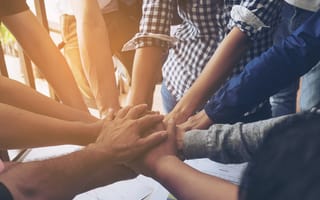 Team members join hands.