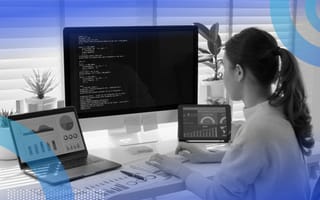 A woman works on multiple computer monitors manipulating data