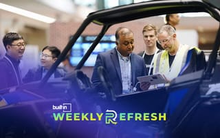 PTC employees look at a vehicle