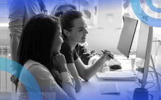 HTML image of two women looking at a computer screen together and collaborating.