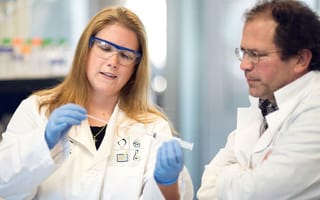 Lab Operations Manager Lindsay Poland (left) and Chief Scientific Officer Mitch Sanders (right) work in Alira Health’s lab in Framingham.