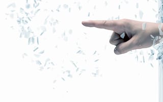 photo of a hand breaking through a pane of glass