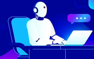 Conversational AI sitting at a desk typing on a laptop.