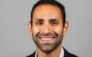 Ali Sabeti, CEO of Zerocater, poses for a photo against a grey background.