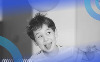 Electrical charge little boy smiling with his tongue sticking out. His hair sticks up and reached toward a balloon.