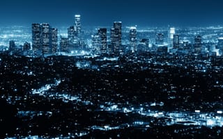 A blue-tinted nighttime photo of the LA skyline.