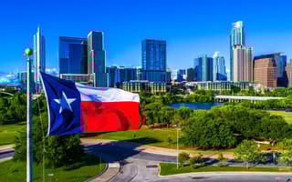 The Texas flag in front of the Austin skyline.