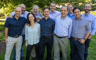 Ten people from Assured Allies’ management team pose for a group photo outside.