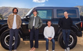 Caramel’s executive team pose together in front of an SUV.