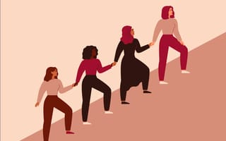 Four women walking up a slope together and holding hands