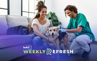 People petting a dog in a living room.