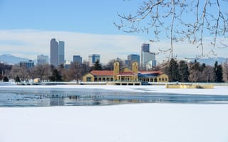 skyline photo of Denver in the snow with a forzen lake in the foreground
