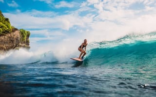 A woman surfs a wave