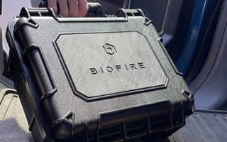 A person taking a Biofire gun case out of a car.