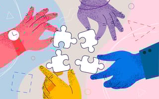 Hands of different colors putting puzzle pieces together