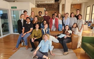 group of people standing and sitting around a couch in Findigs offices.