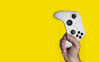 xbox controller in hand on yellow background