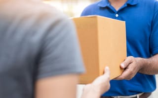 A delivery person hands someone a box.