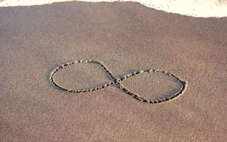 an infinity symbol carved into a sandy beach