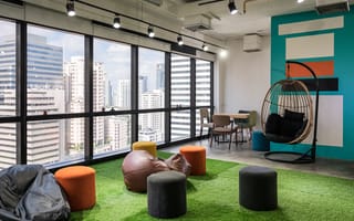Creative room coworking space with cushions and chairs on artificial grass in modern office