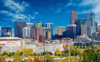 The Denver skyline with Elitch Gardens in the foreground. A rollercoaster is visible.