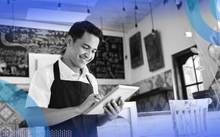 A coffee shop clerk looks at a tablet computer