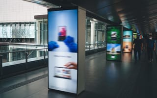 A digital advertisement at a public transportation platform is shown.